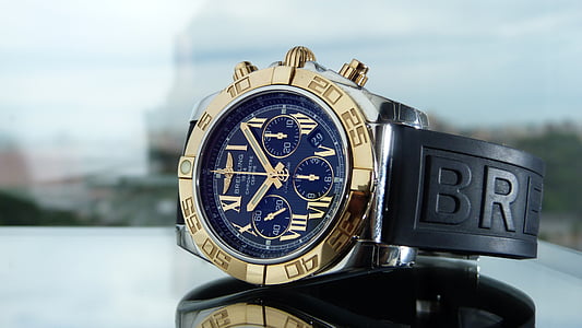 round blue and gold-colored chronograph watch with black strap
