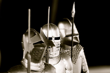 grayscale photo of three knights holding spears