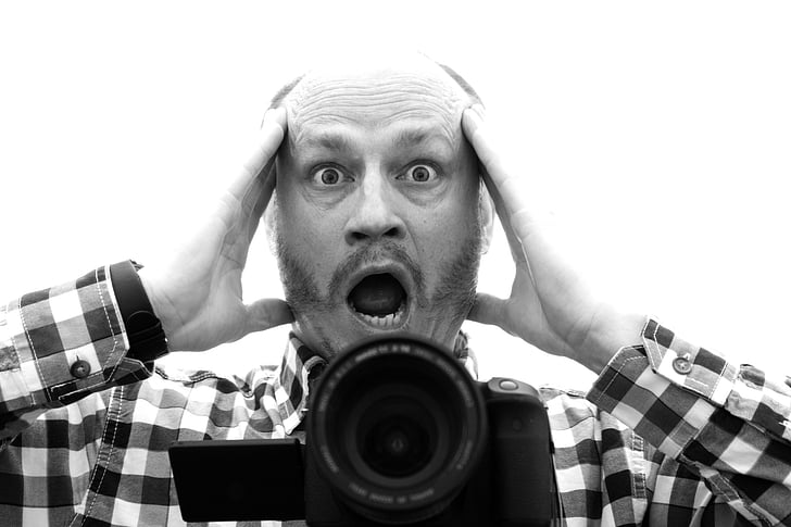 grayscale photo of man screaming with bridge camera in front