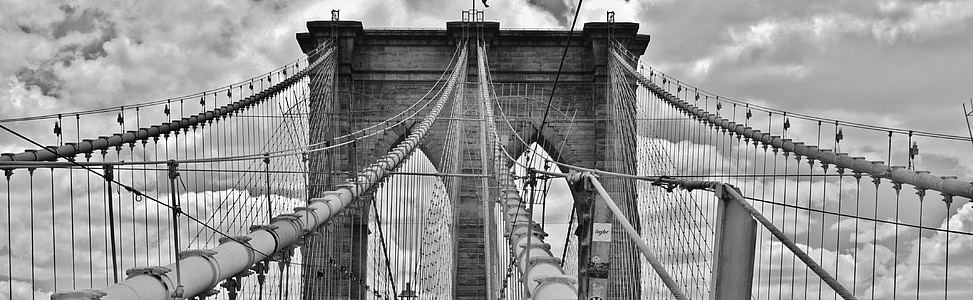 suspension bridge in grayscale photography