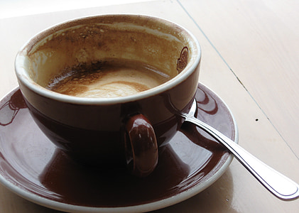 brown ceramic cup on saucer filled with coffee