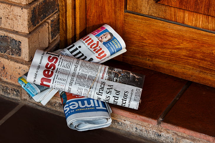 three newspapers on the floor