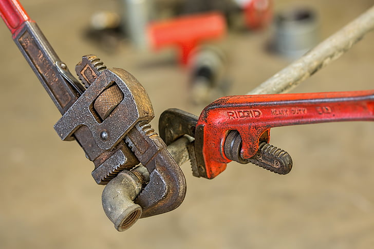 two brown and red RIDGID pipe wrenches