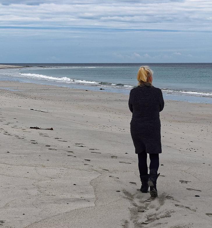 woman walking at seashore under white clouds