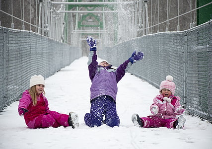 three children playing in snow