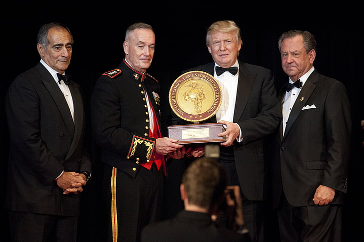 Donald Trump holding award with three men