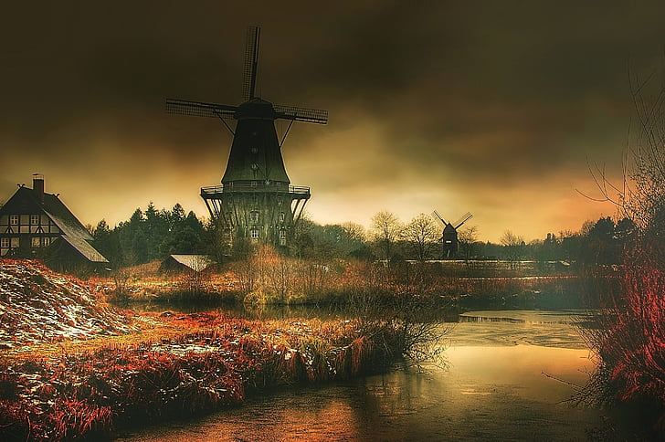 black and gray windmill beside body of water painting