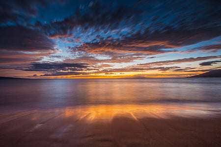 body of water under blue and orange skies during sunset