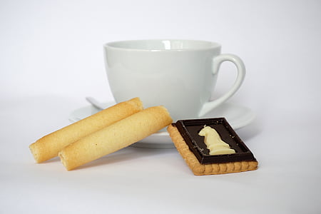 white ceramic teacup with biscuit