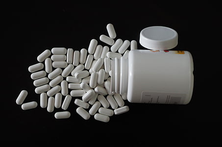 medication capsules beside container