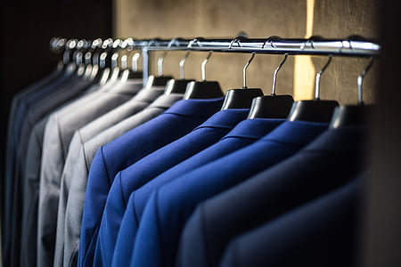 selective focus photography of suit jacket on hangers