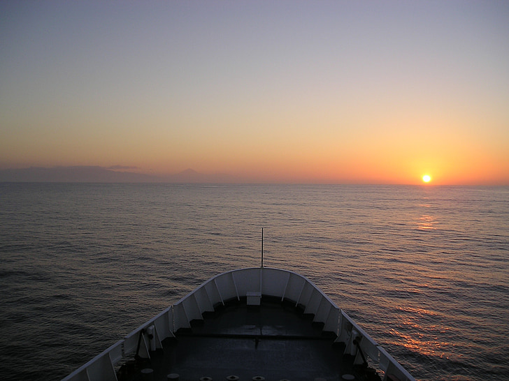 edge of white boat overseeing orange sunset