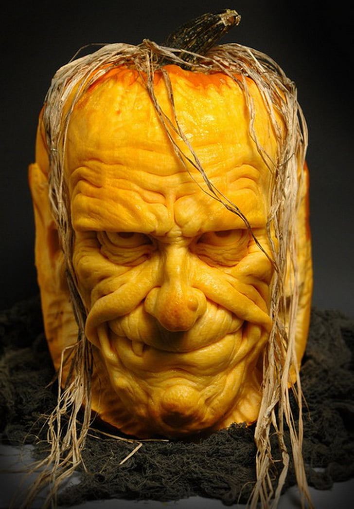 man's face carved pumpkin on black floor