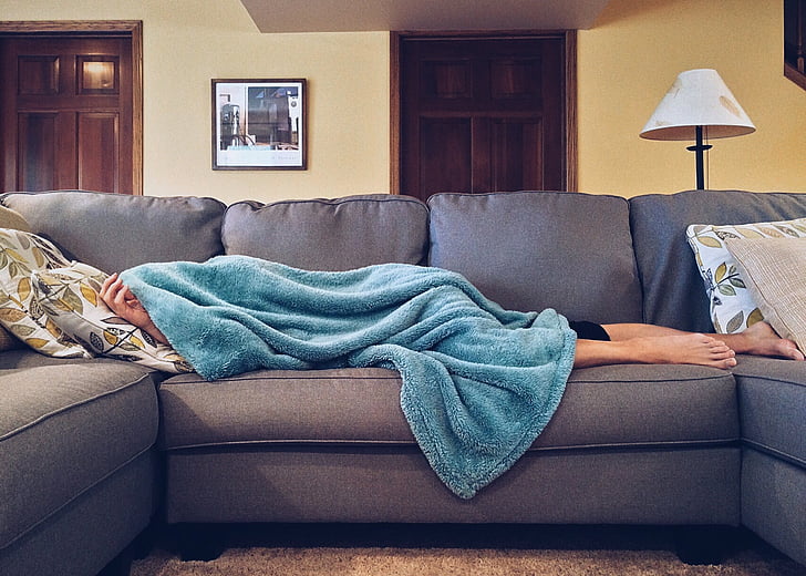 person sleeping in gray sofa