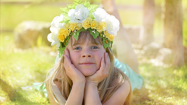 girl wearing flower crown lying on the grass