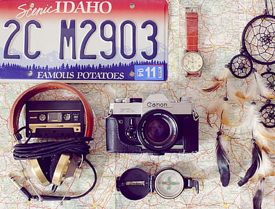 flat lay photography of Canon camera, watch, license plate, and dreamcatcher