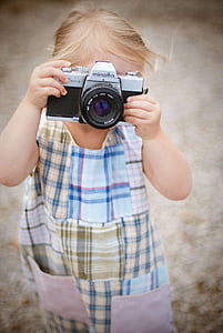 girl holding a gray Minolta camera