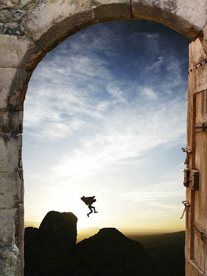 silhouette of person jumping off the cliff during sunrise photo view from dome gray concrete entrance