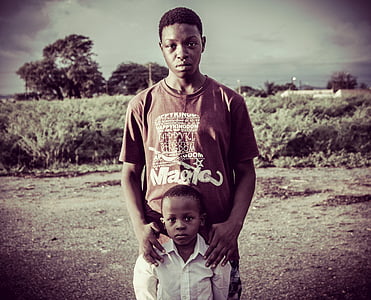 man and child standing near field