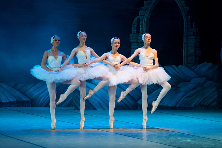 several ballet dancer on tip-toe stance inside well lighted room