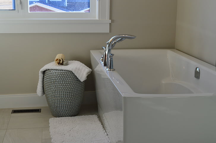 white fleece towel beside white bathtub