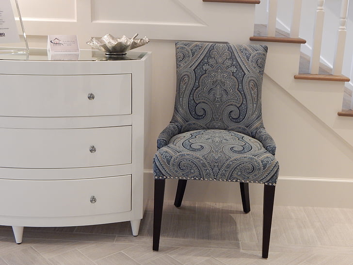 photo of blue and gray chair near white wooden 3-drawer chest