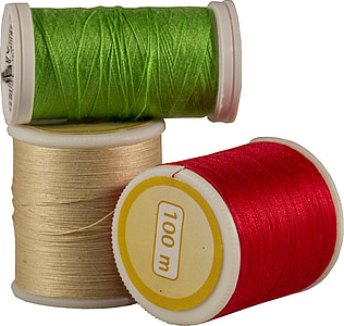 three green, red, and brown sewing threads