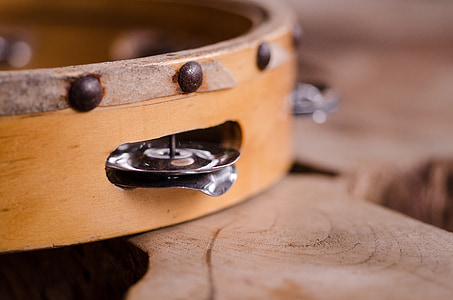 closeup of brown tambourine on wood slab