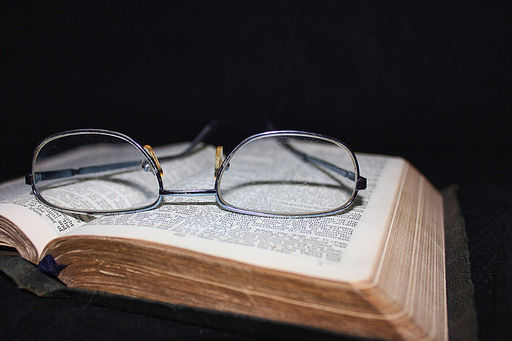 eyeglasses with silver frame on book page