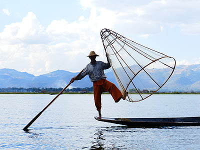 man standing in front of boat holding fishing basket