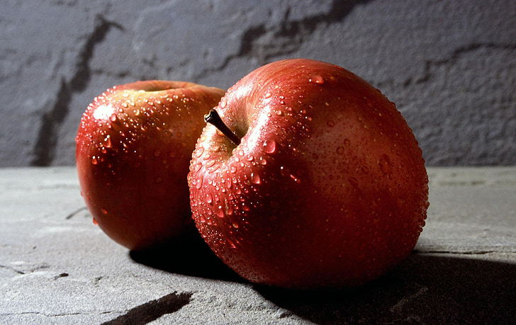 two red apples on gray stone