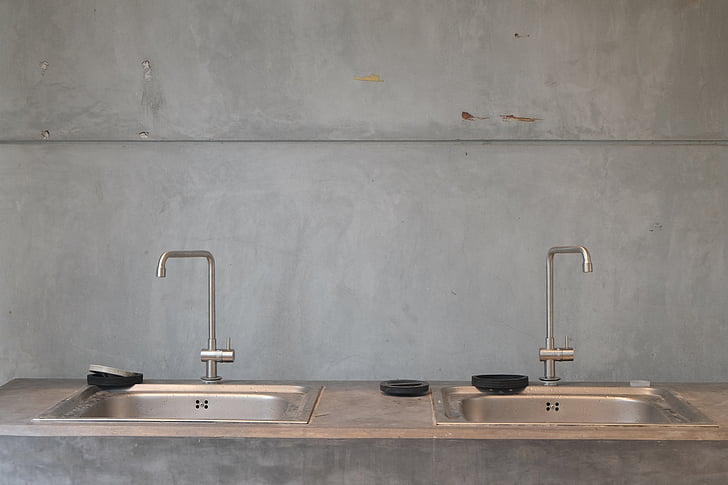 two gray sinks with faucets