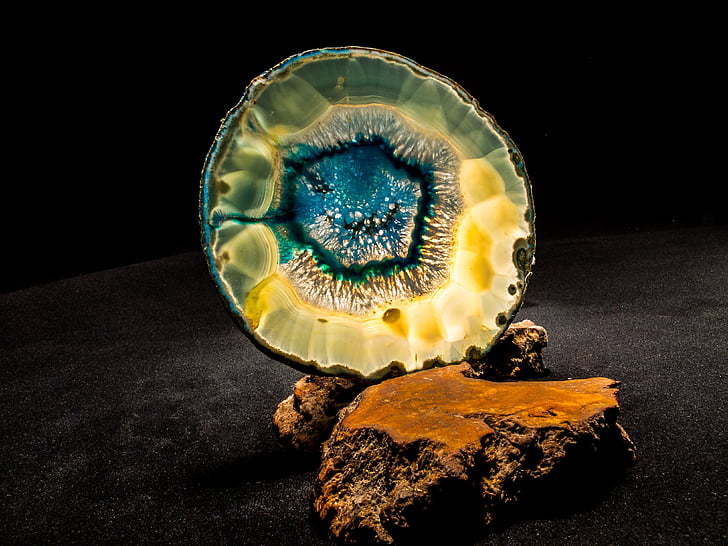 blue and brown geode on brown rock