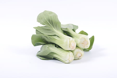 photo of bunch of bokchoy on white surface