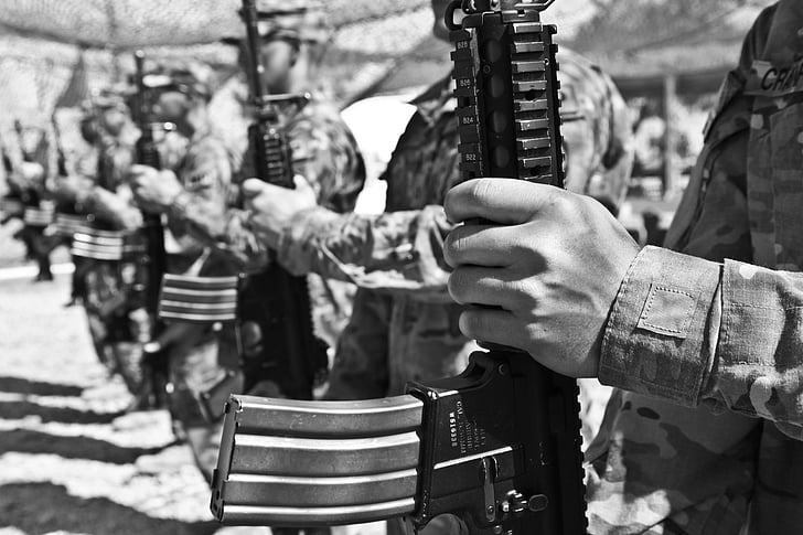 soldiers holding rifles in grayscale photography