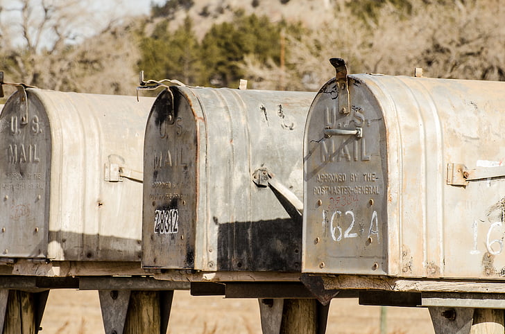 closeup photography of three gray U.S. mailboxes