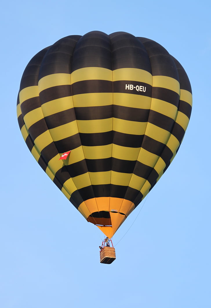 people riding on yellow and black hot air balloon