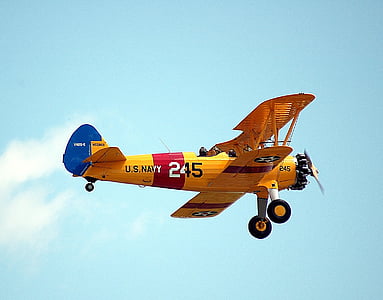 yellow and red U.S. Navy 245 plane under white clouds during daytime