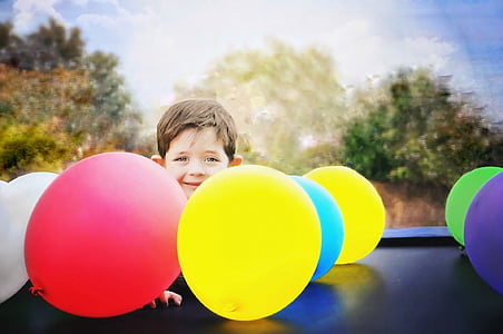 boy near assorted-color balloons