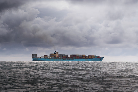 photo of blue cargo ship in body of water during daytime