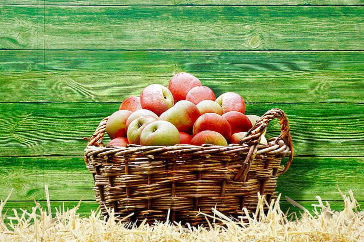 basket full of apples near wall