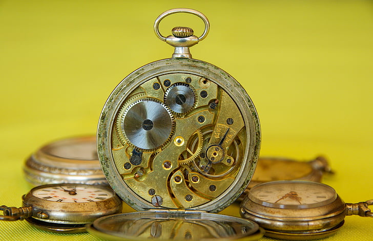 selective photography of round gold-colored and white pocket watch