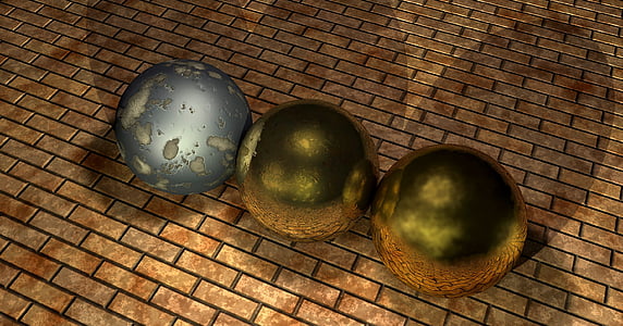 three gray and green balls on brown concrete brick wall
