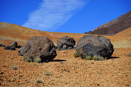 three brown rocks under blue skies