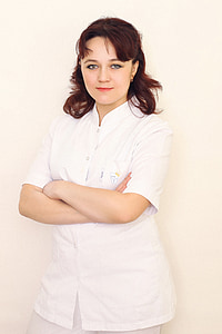 woman wearing white button-up shirt standing beside white wall