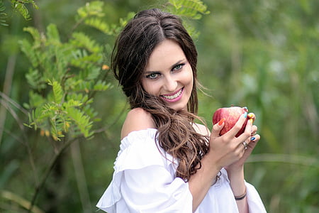woman holding apple fruit wearing white off-shoulder blouse