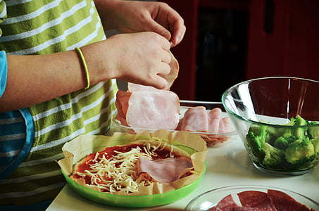 person slicing ham on table