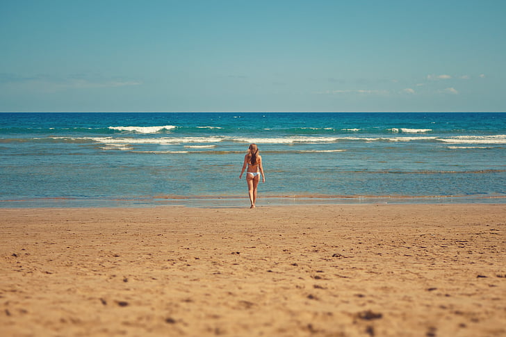 woman standing on seashore during daytime