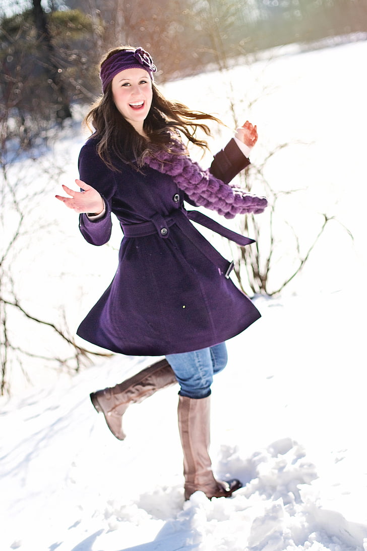 woman in purple coat on snow field