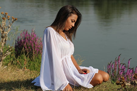 woman wearing white dress sitting on grass